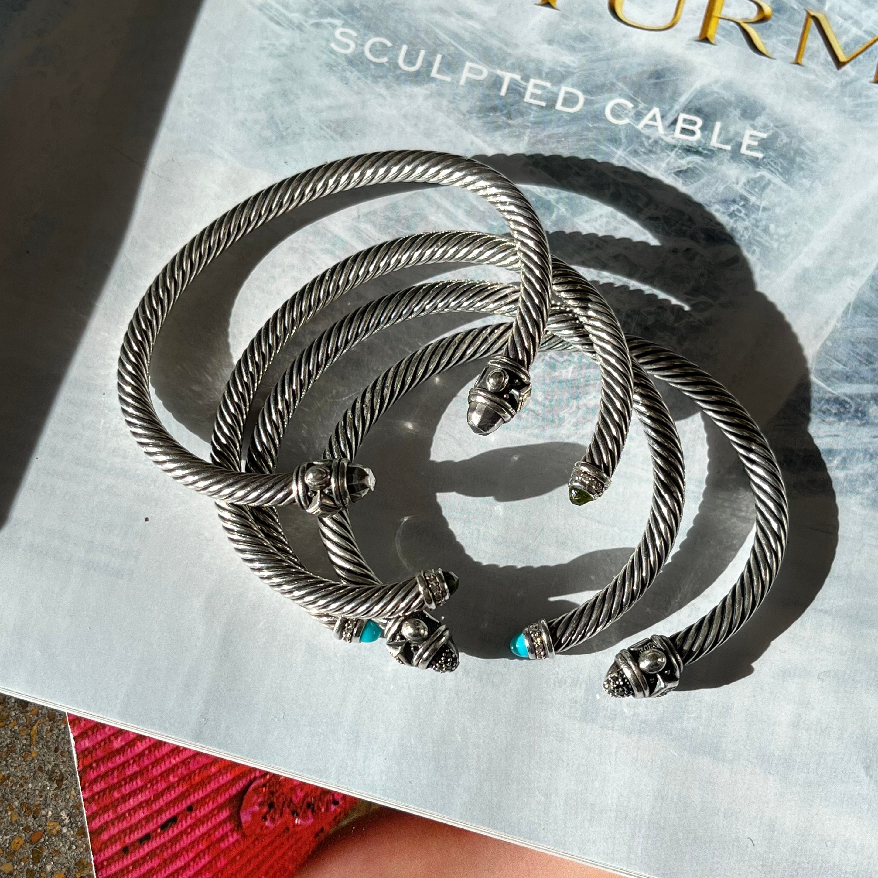 Stacked David Yurman bracelets.