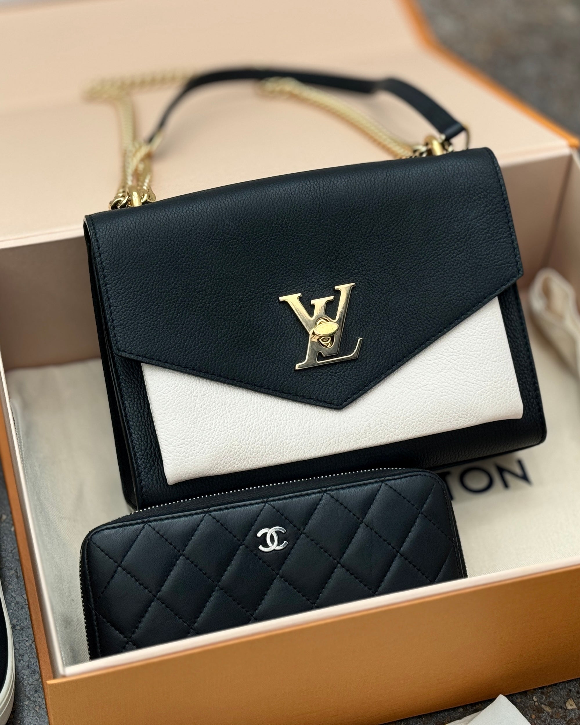 Photo of a Louis Vuitton handbag and Chanel wallet in a Louis Vuitton box.