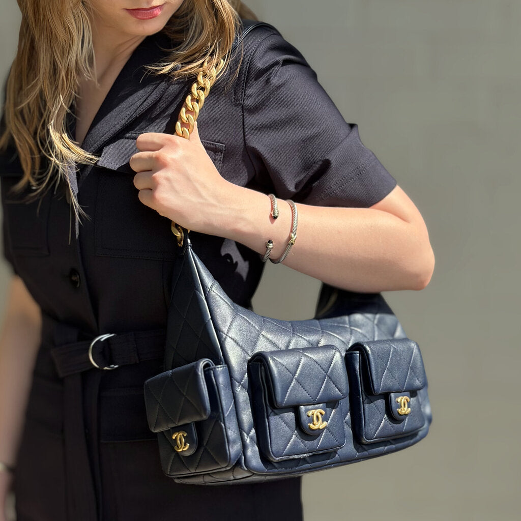 Navy quilted shoulder bag set on model, gold chain straps and CC logo accents