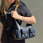 Navy quilted shoulder bag set on model, gold chain straps and CC logo accents