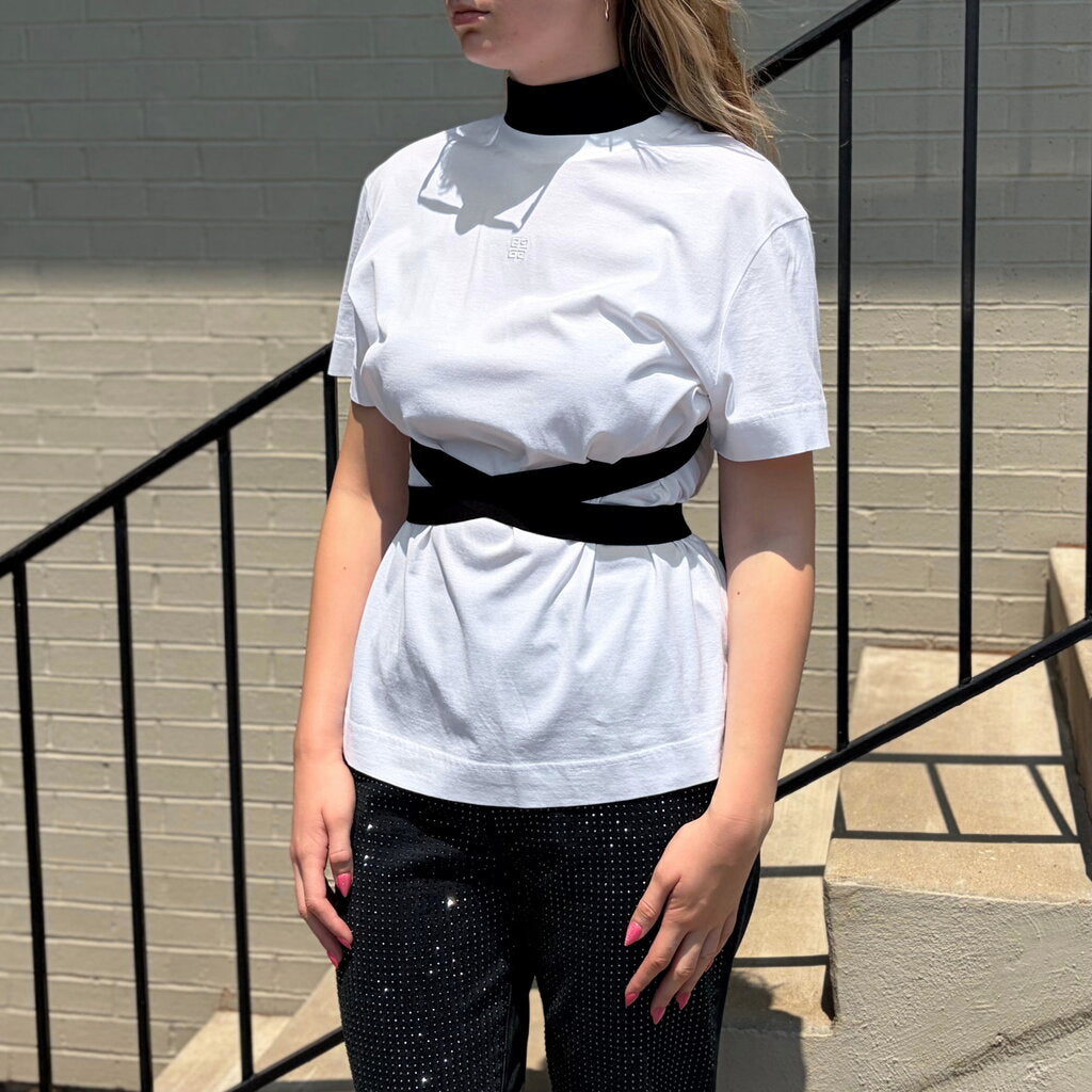 White short-sleeve wrap-tie tee with black waist belt and small chest logo