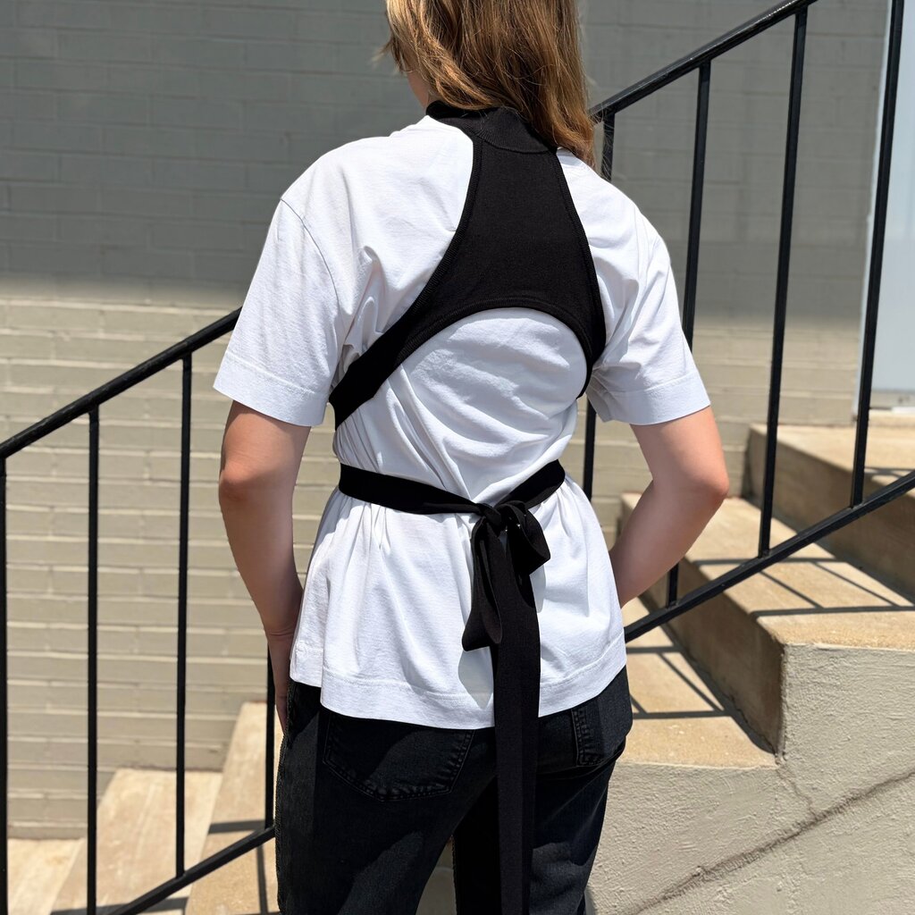 White short-sleeve wrap-tie tee with black crisscross straps and waist tie