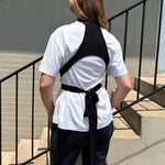 White T-shirt with black wrap straps across back and waist tie, short sleeves