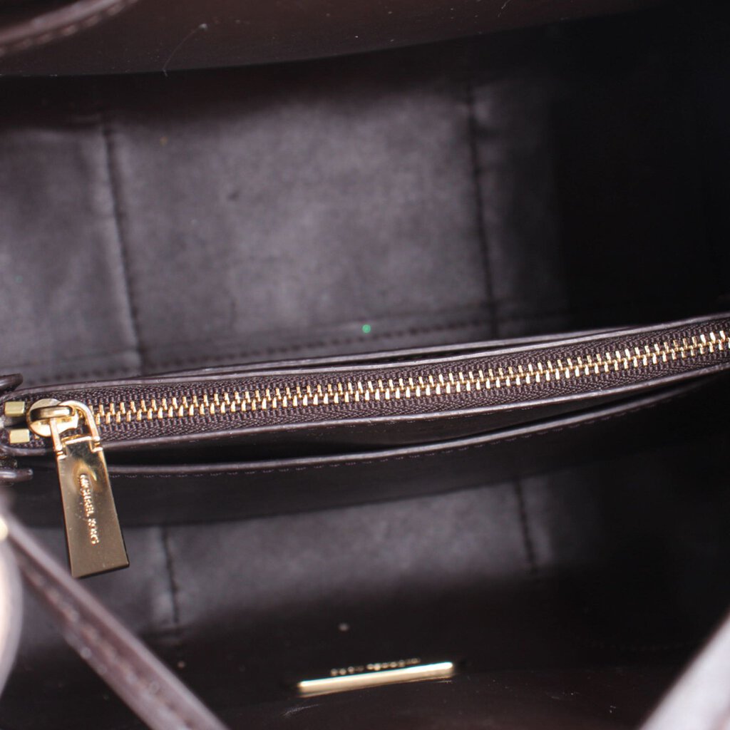 Inner view of medium crossbody bag with gold-tone zipper and dark lining