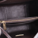 Inner view of medium crossbody bag with gold-tone zipper and dark lining