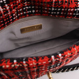 Red tweed bag interior lining with gold-tone logo label and zipper edge