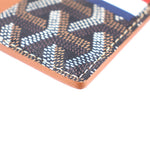 Men’s card case wallet corner close-up, orange edge trim and dark monogram fabric