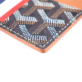 Men’s card case wallet bottom corner close-up, stitched dark monogram and orange edge