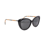 Cat-eye sunglasses with dark lenses; check-pattern arms in black, beige, red accents