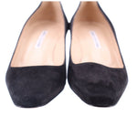 Black suede pumps close-up with light inner lining at the opening