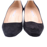 Black suede pumps close-up with beige insole and rounded instep.