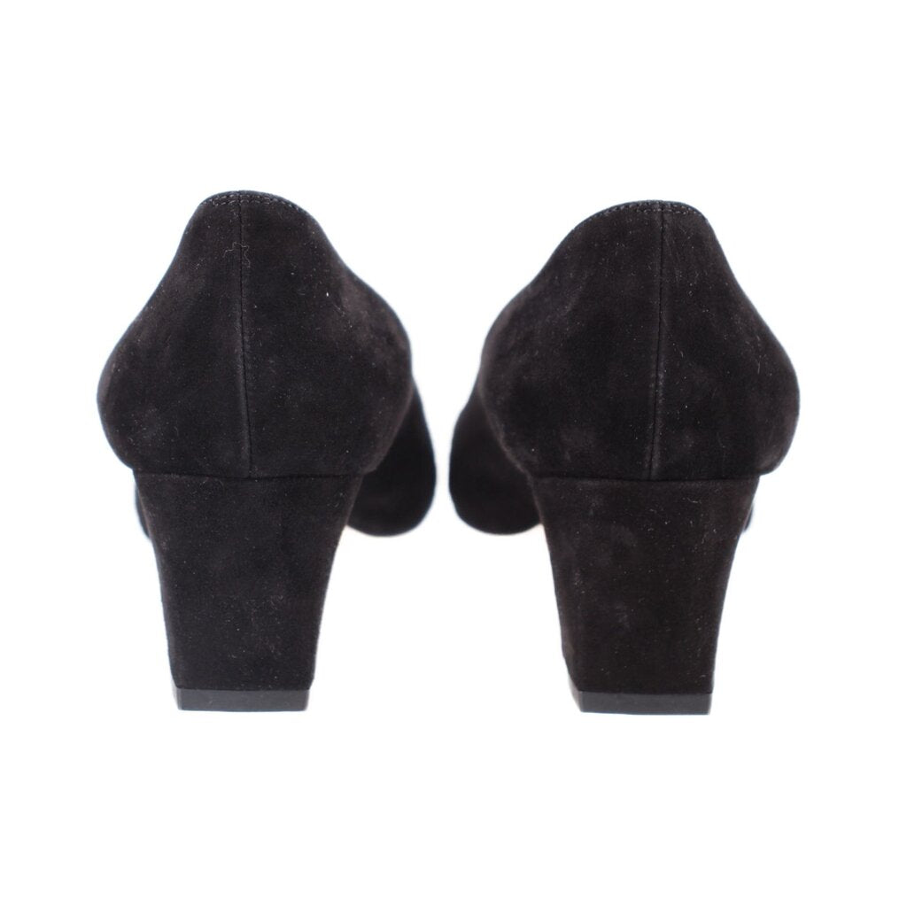 Black suede heels from the back, showing heel shape and toplift.