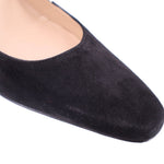 Black suede pointed toe pump close-up with smooth vamp seam
