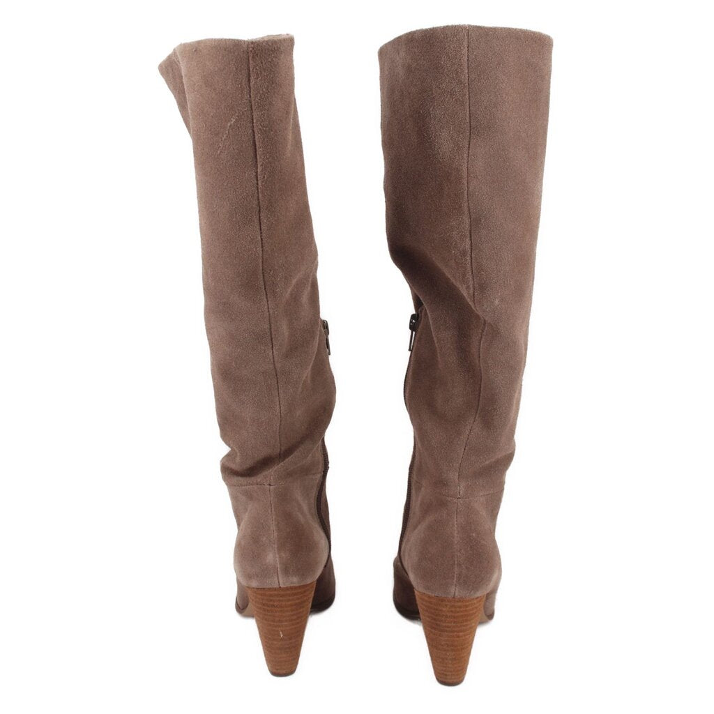 Tan suede tall boots with visible back zipper and stacked wood heel