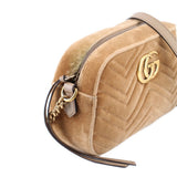 Tan velvet crossbody bag side view with gold GG plaque, zipper edge, and leather trim.