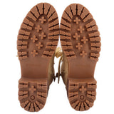 Tan combat boot outsoles with deep tread and star-shaped traction pattern.