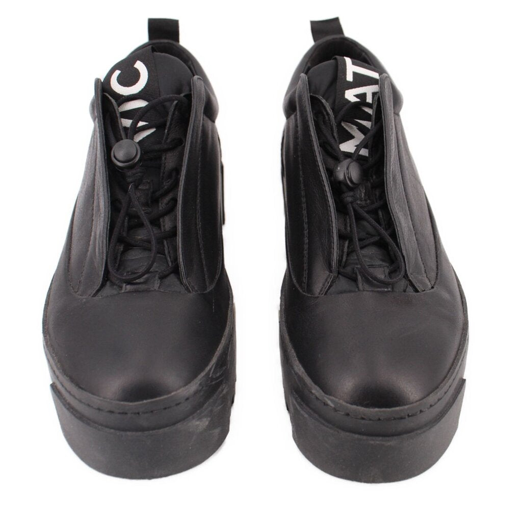 Pair of black platform sneakers with lace-up eyelets and side panels