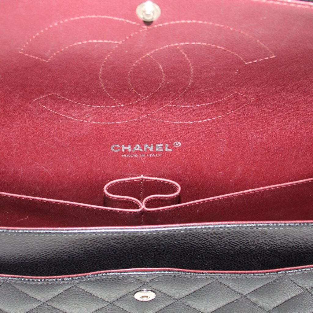 Red CHANEL-lined interior with logo and snap pocket inside black jumbo double flap bag