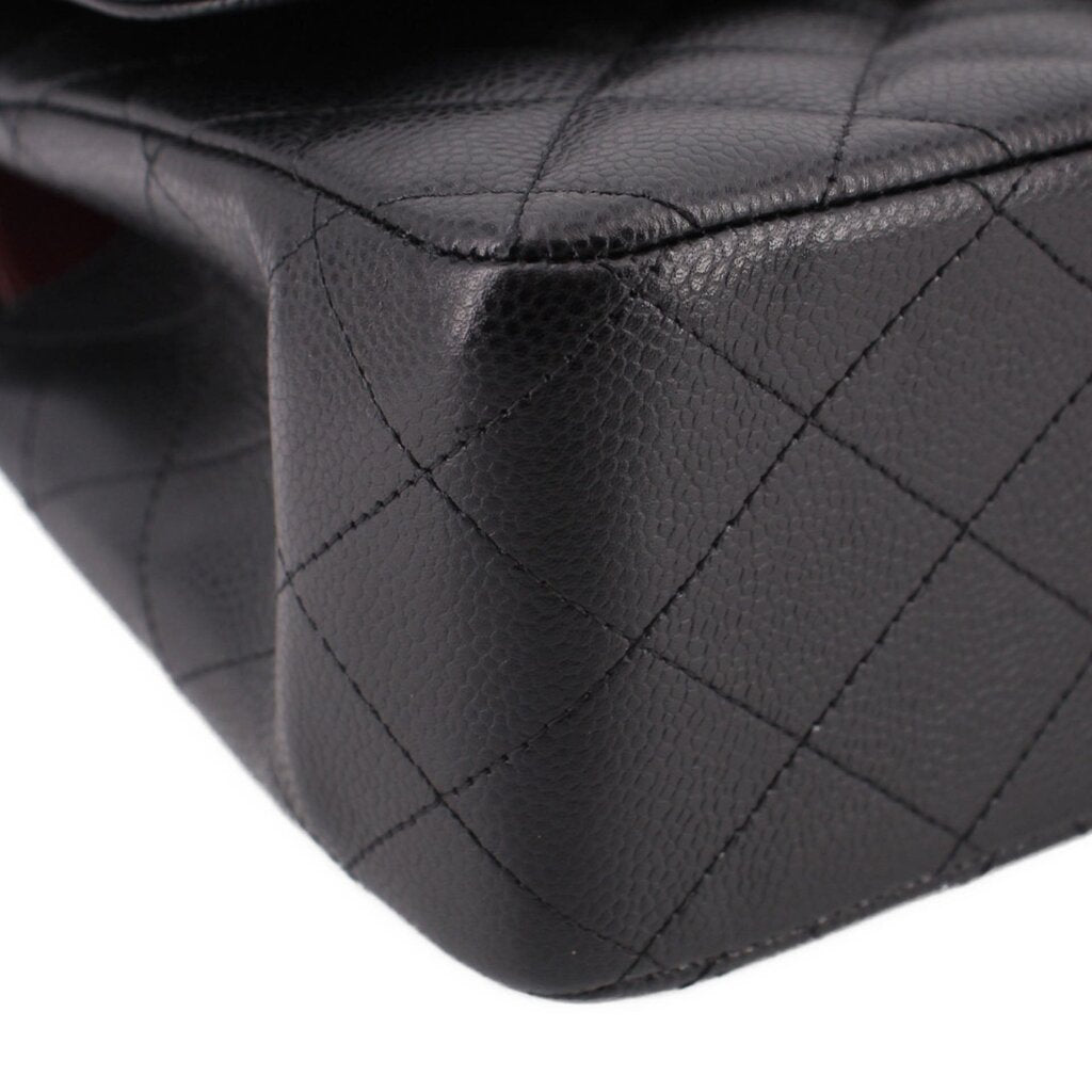 Black leather texture close-up with diamond quilting seam lines on jumbo double flap