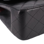 Black leather texture close-up with diamond quilting seam lines on jumbo double flap