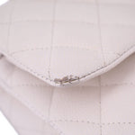 Close-up of off-white quilted CHANEL bag corner showing worn stitching