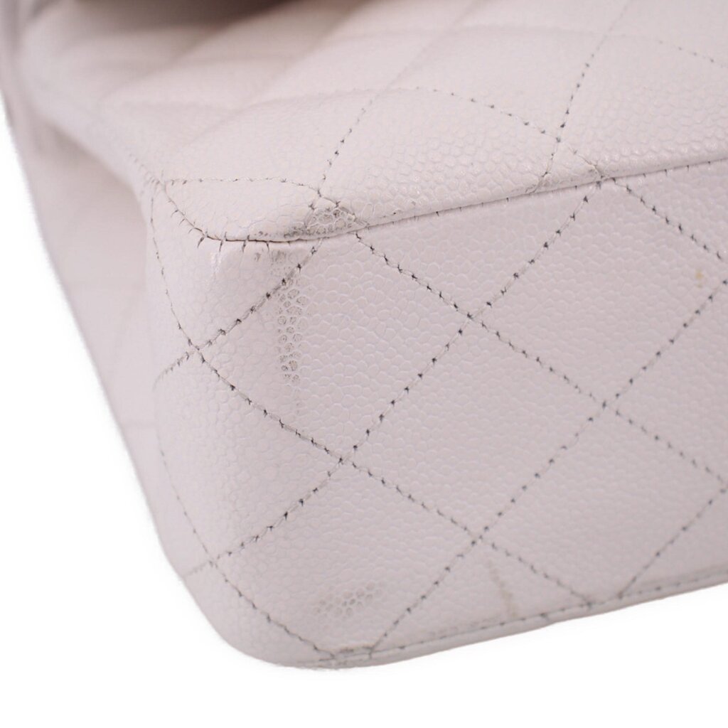 Close-up of off-white quilted CHANEL bag corner with stitched diamond pattern