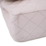 Close-up of off-white quilted CHANEL bag corner with stitched diamond pattern