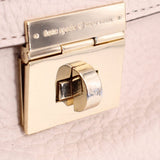 Gold turn-lock clasp with engraved logo plate on Thatcher tote