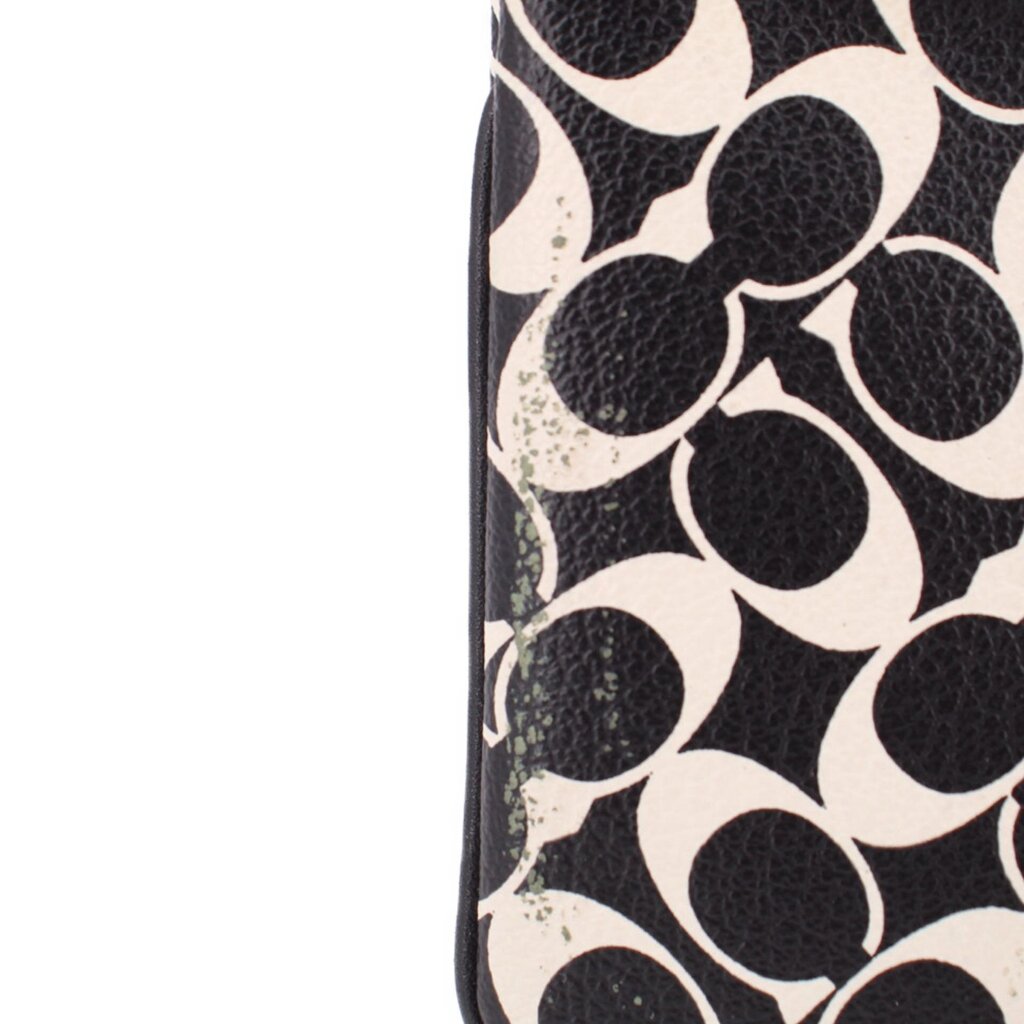 Logo canvas wristlet pouch close-up, textured black and cream pattern, stitched edge