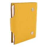 Yellow textured notebook cover partially open with white pages and snap hardware