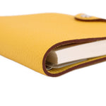 Yellow cover corner close-up with rounded edge and layered insert pages