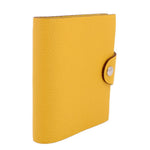 Yellow notebook cover, side view with snap closure and pebbled leather texture