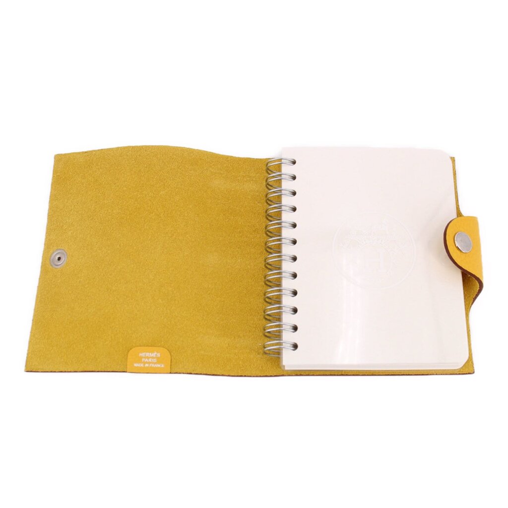 Yellow notebook cover open, spiral binding and white insert pages inside