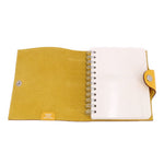 Yellow notebook cover open, spiral binding and white insert pages inside