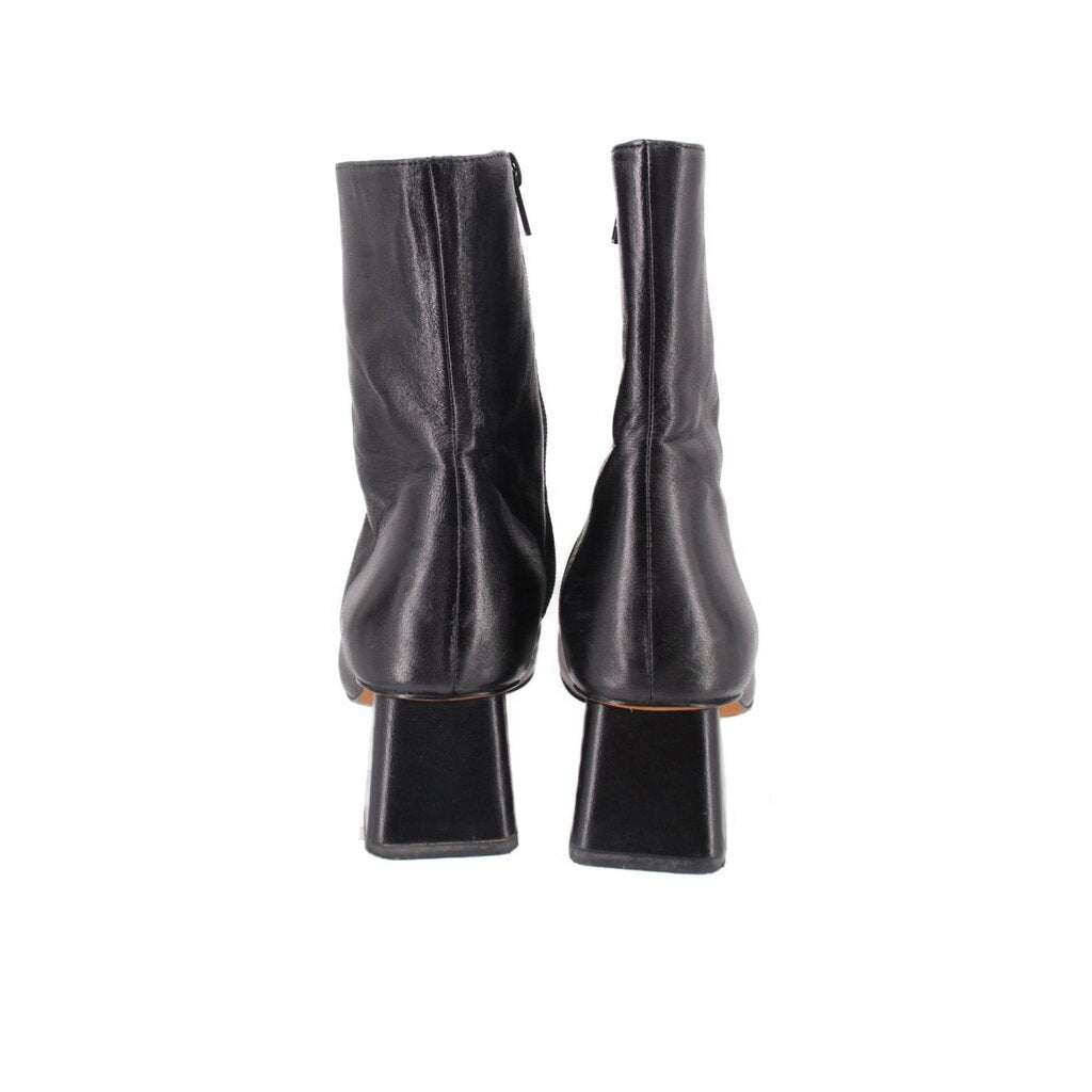 Black leather ankle booties showing back seam and chunky block heel