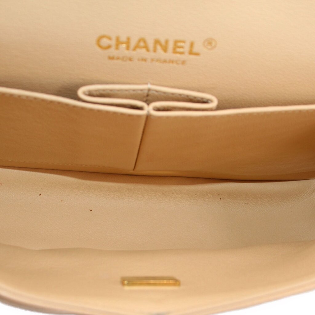 Tan interior of small double flap shoulder bag with CHANEL logo and clasp ring