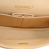 Tan interior of small double flap shoulder bag with CHANEL logo and clasp ring