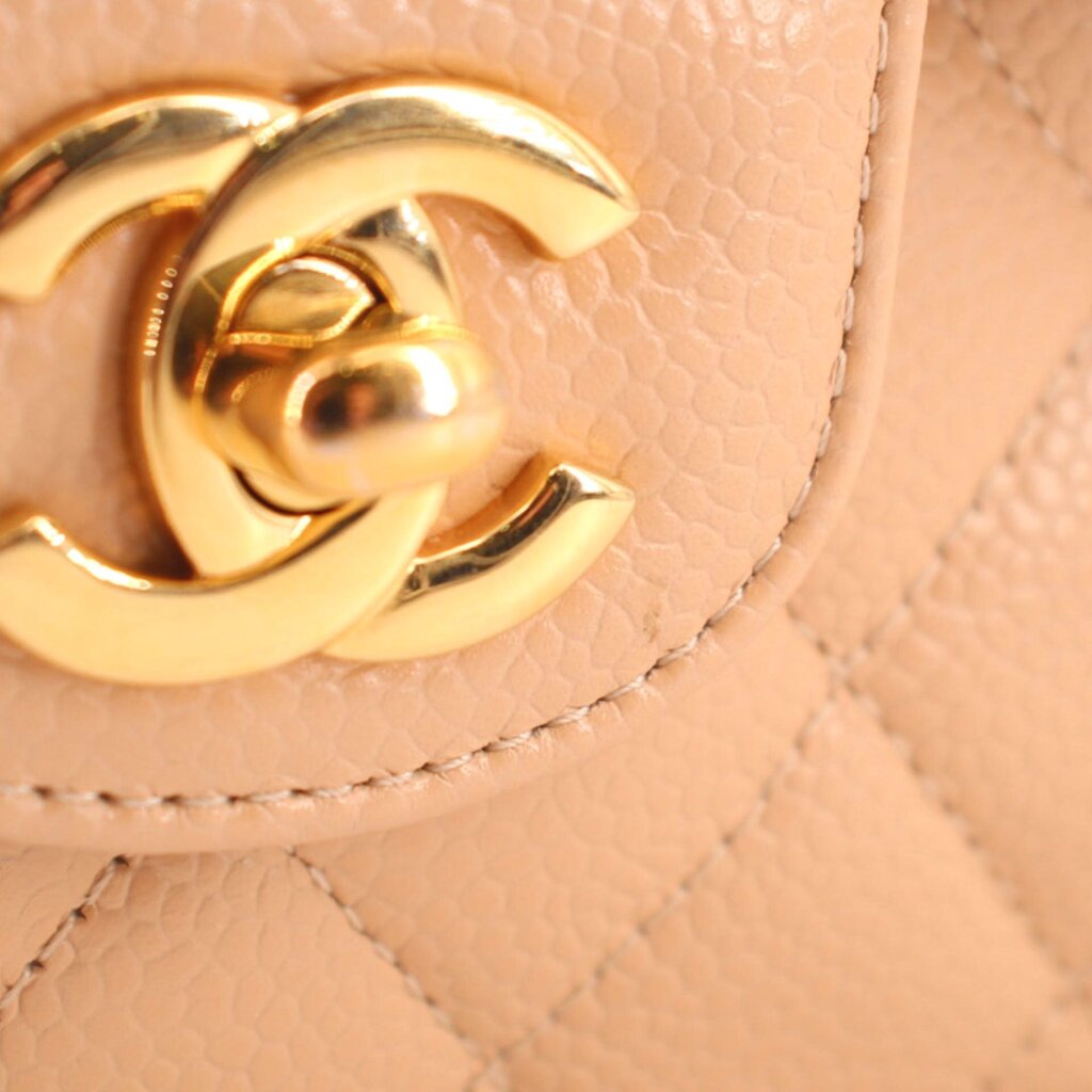 Tan flap clasp hardware in gold tone on small double flap shoulder bag