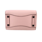 Pink pebbled leather mini bag with top flap and black metal corner details
