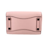 Pink pebbled leather mini bag with top flap and black metal corner details