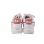 White Nike platform sneakers with pink heel tabs and NIKE branding on back