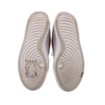 Bottom view of white Nike platform sneaker outsoles with grippy tread pattern