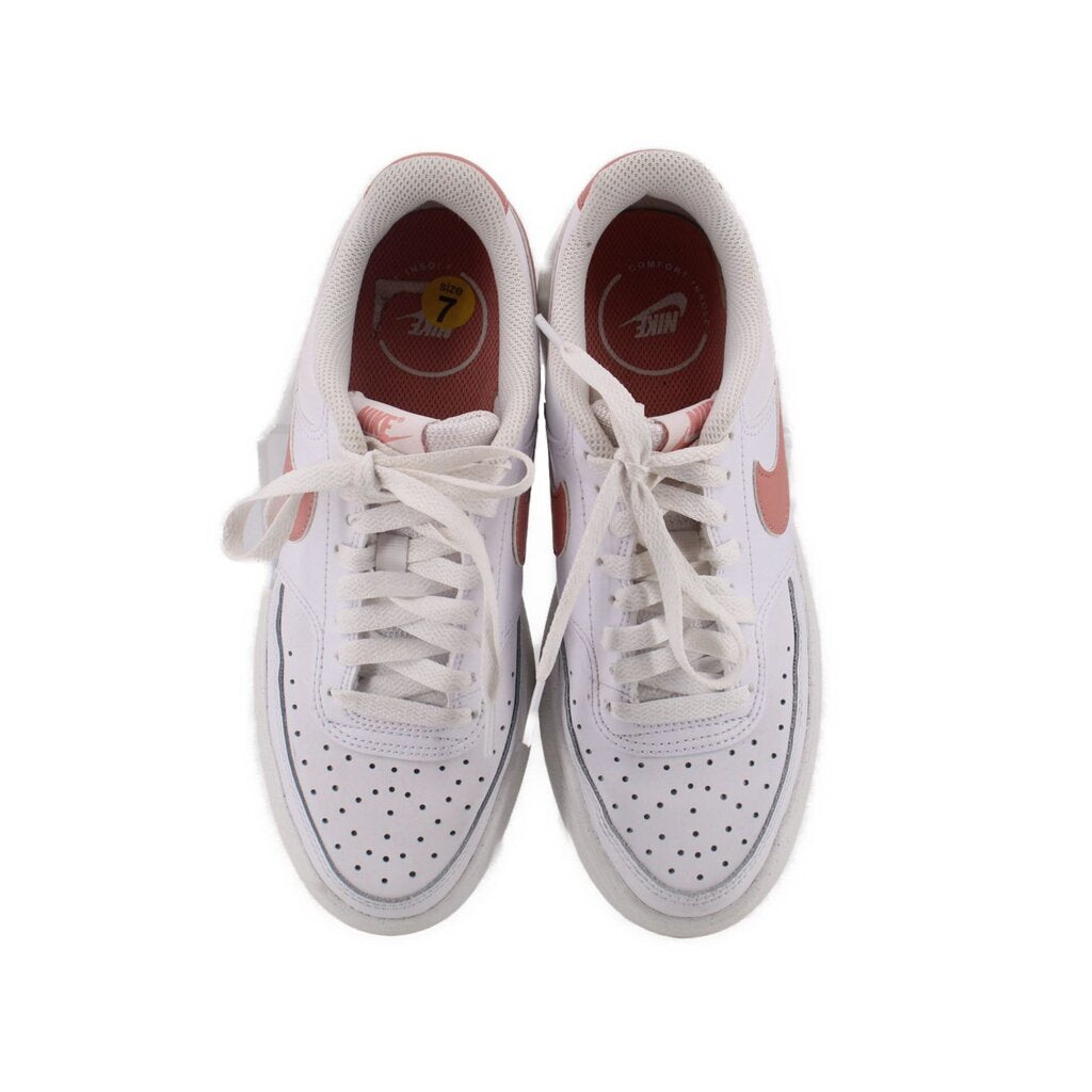 Pair of white Nike lace-up platform sneakers with perforated toe and padded collar