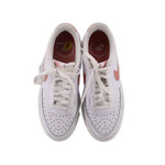 Pair of white Nike lace-up platform sneakers with perforated toe and padded collar