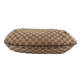 Brown GG canvas crossbody bag with top zipper across the rounded flapless opening