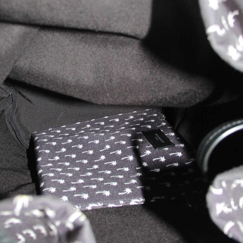 Inside pocket detail of black palm-print backpack lining with label tab