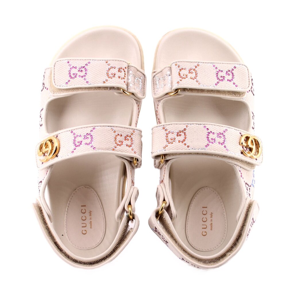 Pair of cream sandals with rhinestone straps and gold-tone GG buckle at instep