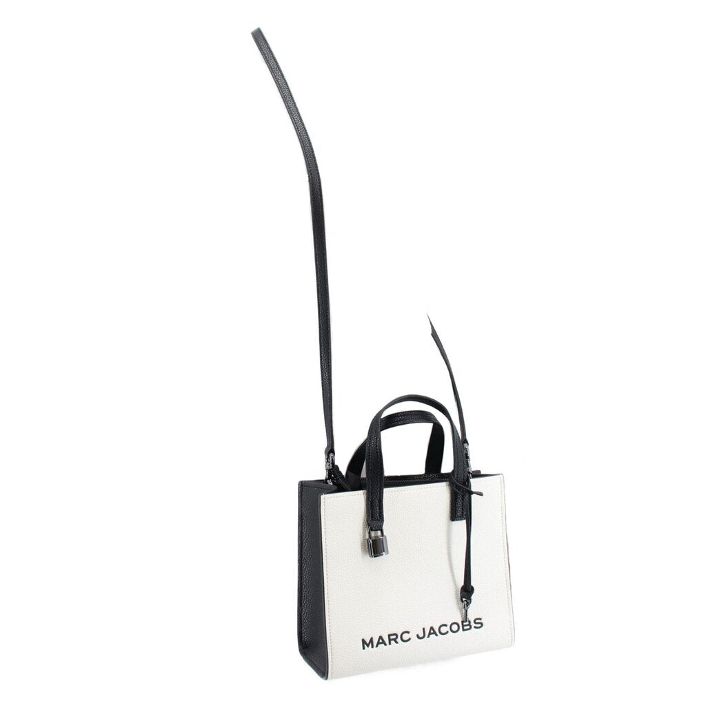 White mini tote with black panels and crossbody strap, brand text on front