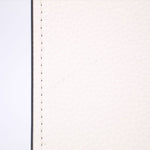 Close-up of white leather exterior with visible stitching along the edge