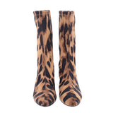Pair of leopard print ankle booties, pointed toes, stiletto heels, brown.